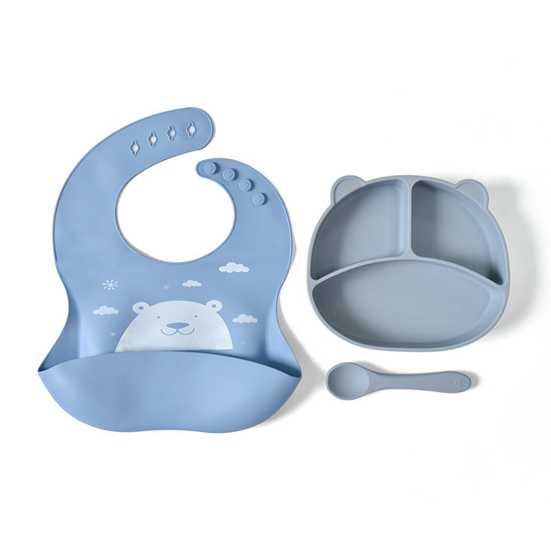 Blue baby bib, bowl, and spoon set on a white background