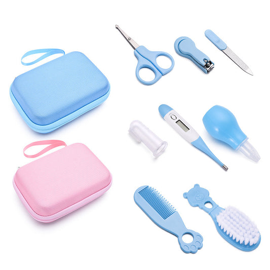 Collection of baby care items including a blue and pink case, scissors, nail clippers, thermometer, and grooming tools on a white background