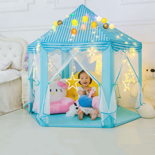 Child playing inside a blue striped play tent with string lights and toys.