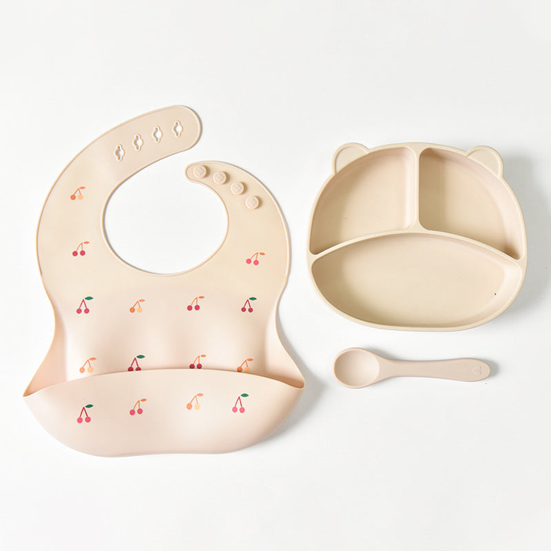 Baby bib, bowl, and spoon set with cherry pattern on a white background