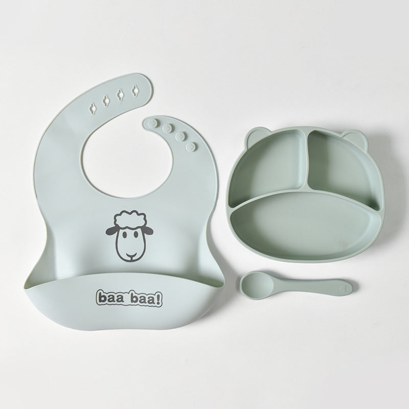 Light green baby bib, bowl, and spoon set on a white background